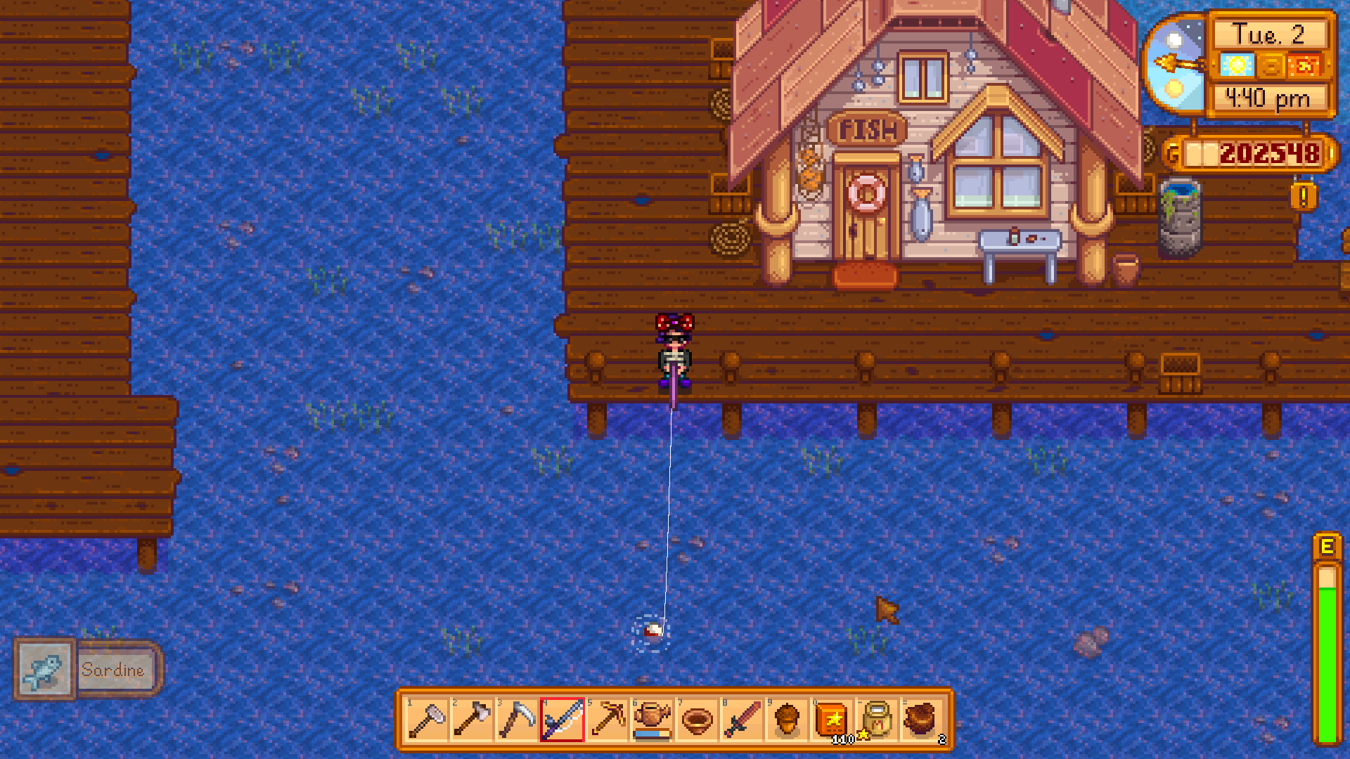 The player character holding a pink fishing rod, fishing in front of a store that says FISH over the door